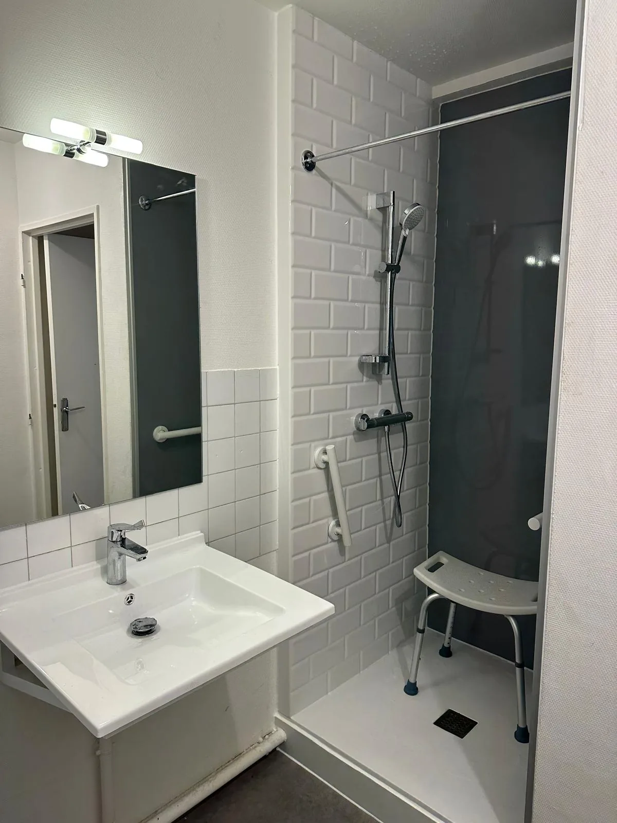 Douche adaptée avec siège et barre d’appui