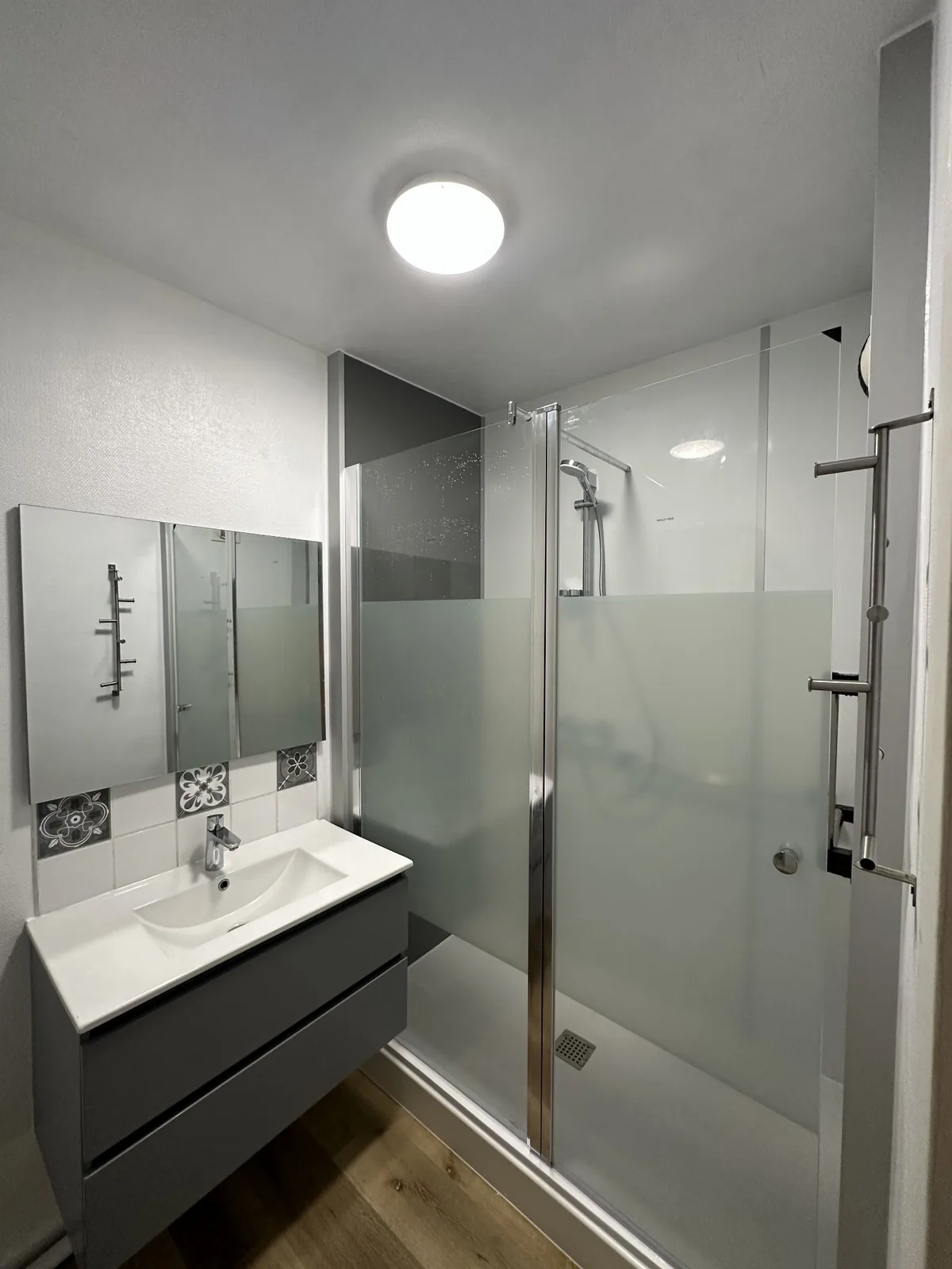 Douche terminée avec paroi vitrée et meuble gris