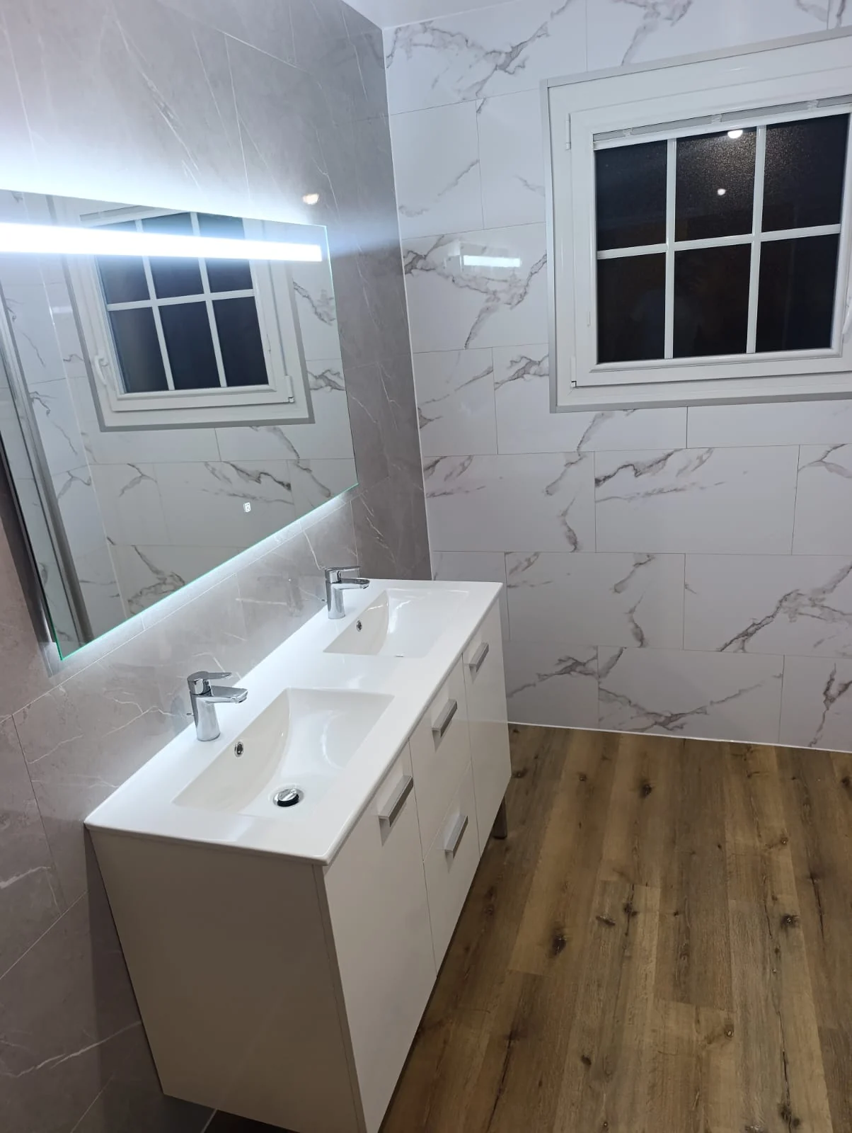 Double vasque blanche et miroir lumineux après rénovation