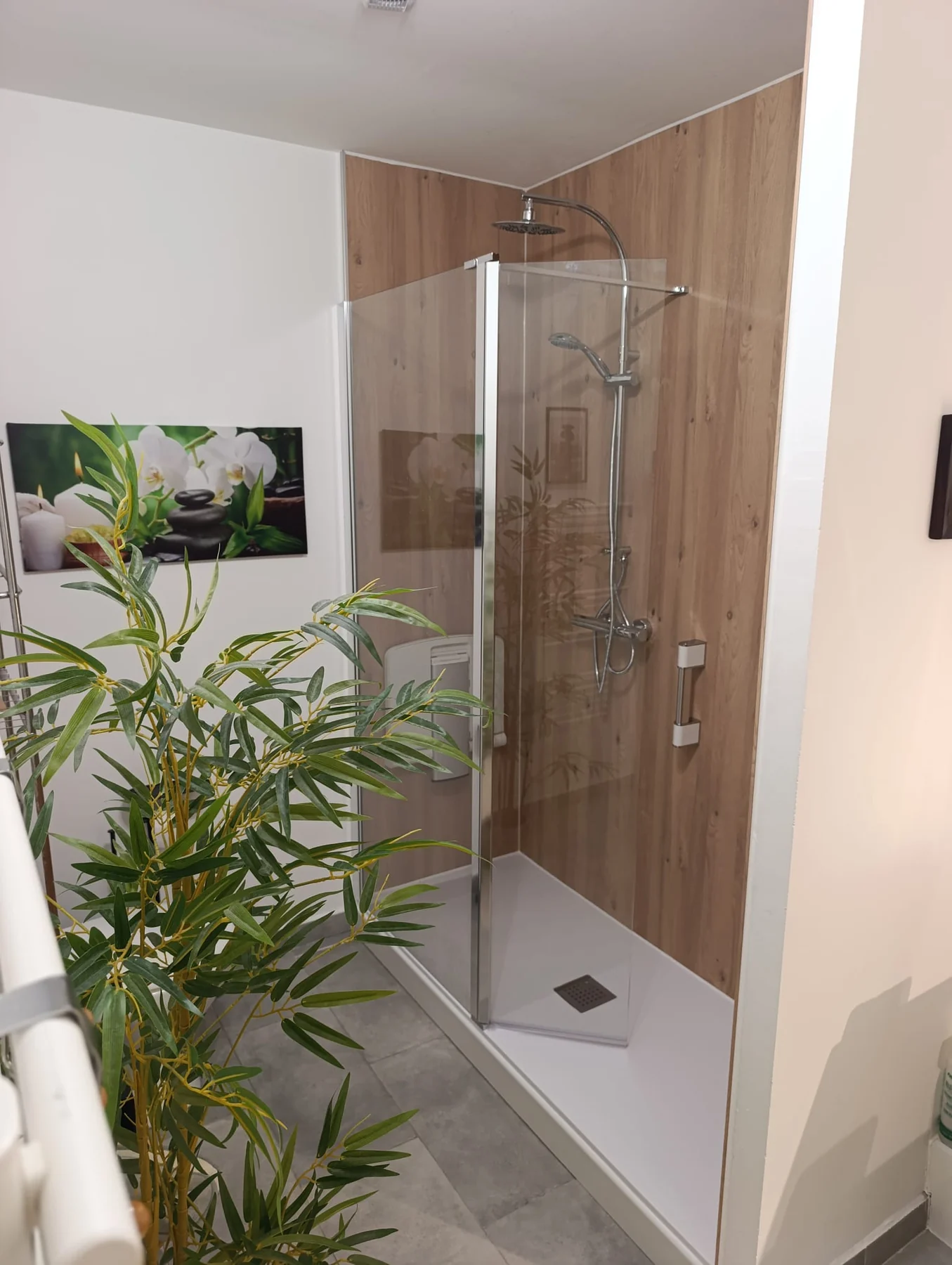 Douche terminée avec receveur blanc, paroi vitrée et panneaux finition bois